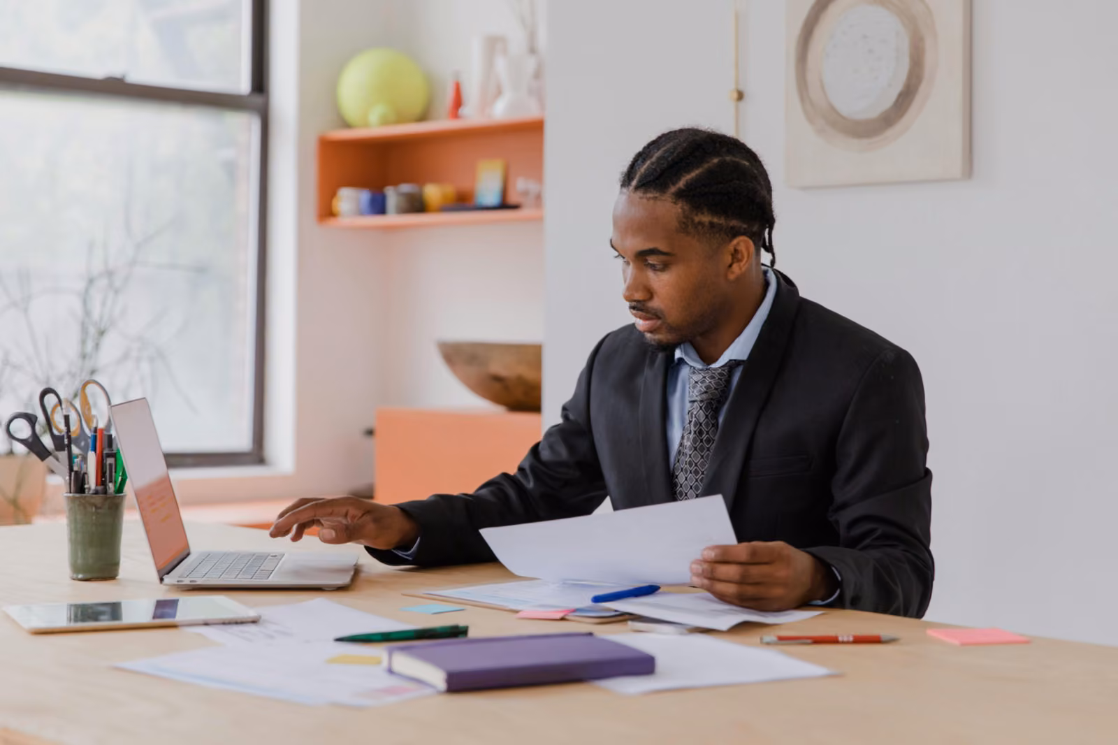 A business owner reviewing paperwork at a desk in a small office