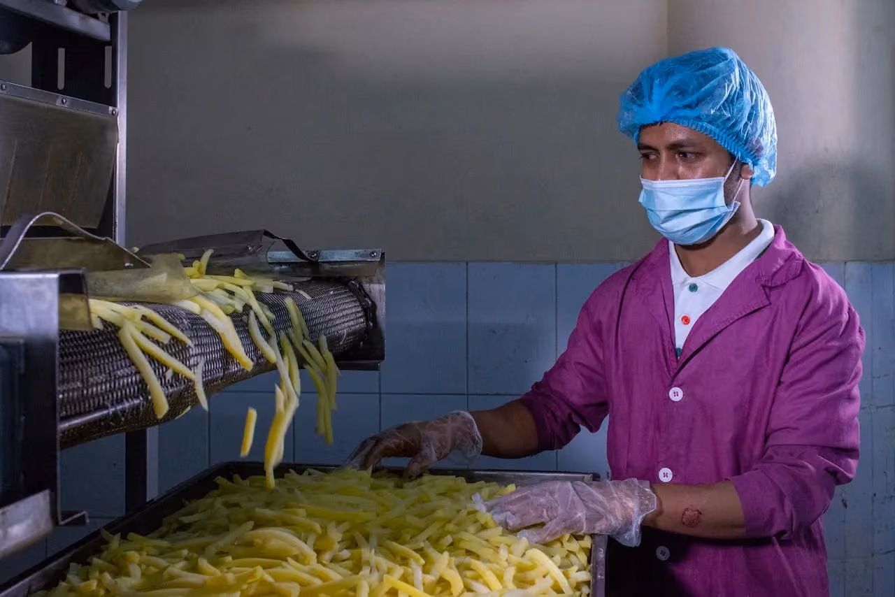 Worker inspecting products on a factory floor during production