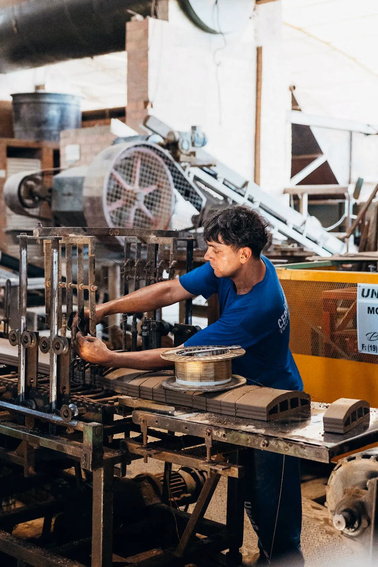 Industrial worker operating machinery on a factory production line