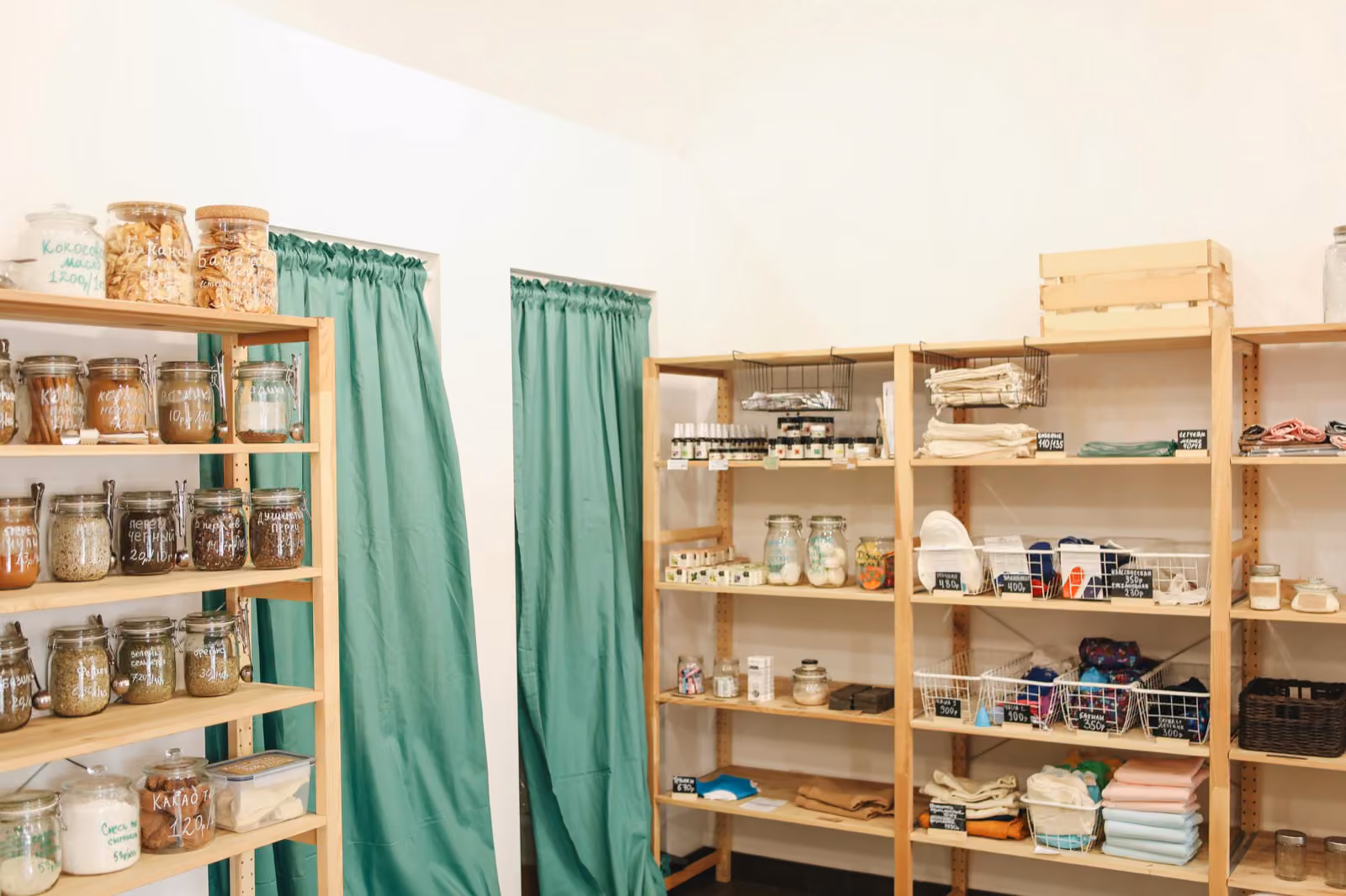 A small retail shop interior with a friendly shopkeeper at the counter