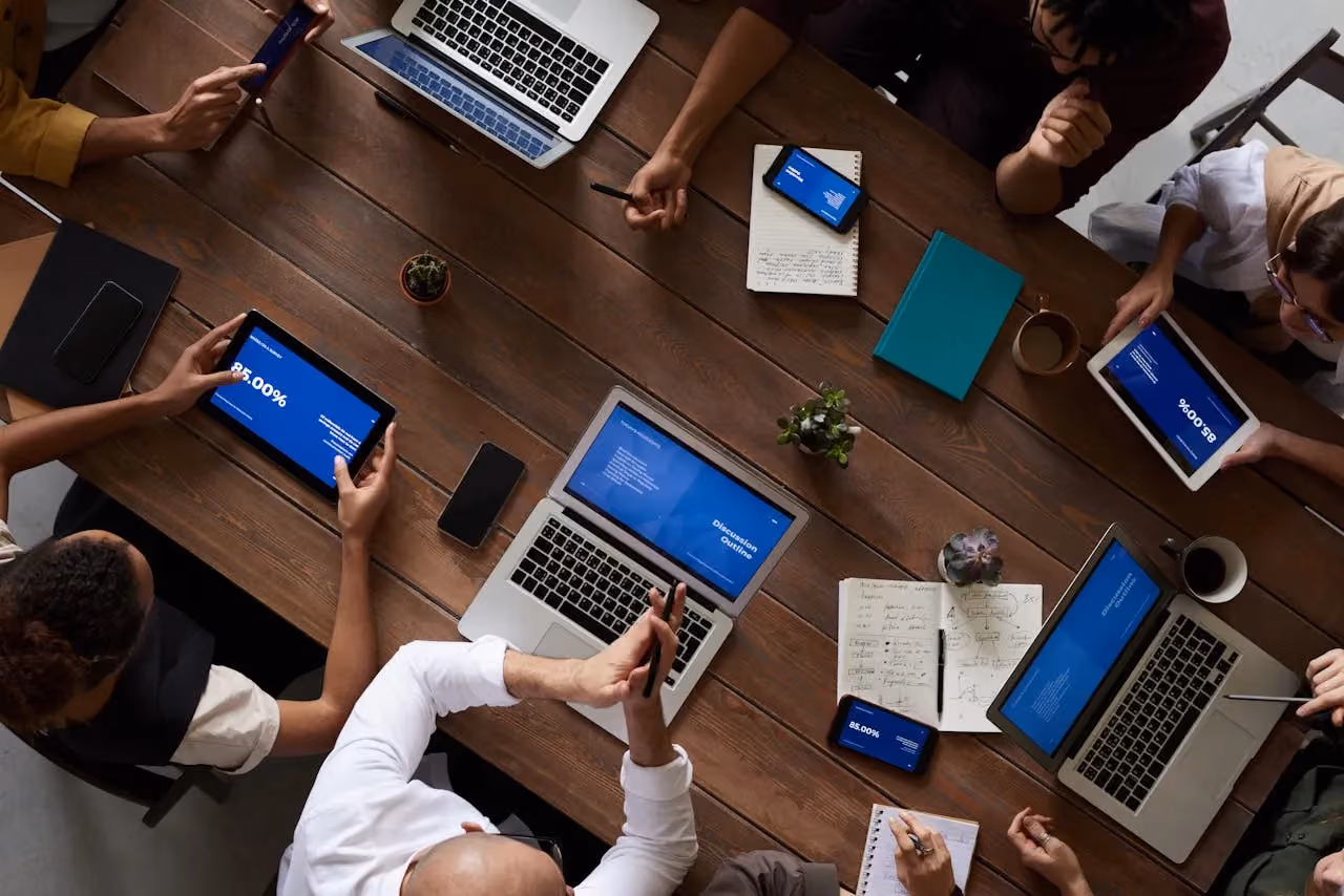 A team having a business meeting around a table with laptops, similar to the advisory sessions offered through the Made Smarter programme