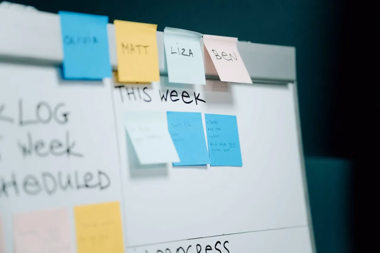 Close-up of colourful sticky notes on a whiteboard, used for task planning and organising marketing priorities