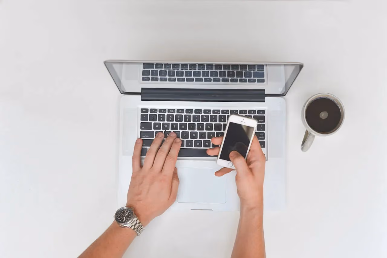 A smartphone next to a cup of coffee on a desk, representing how business calls and enquiries now come through mobile devices