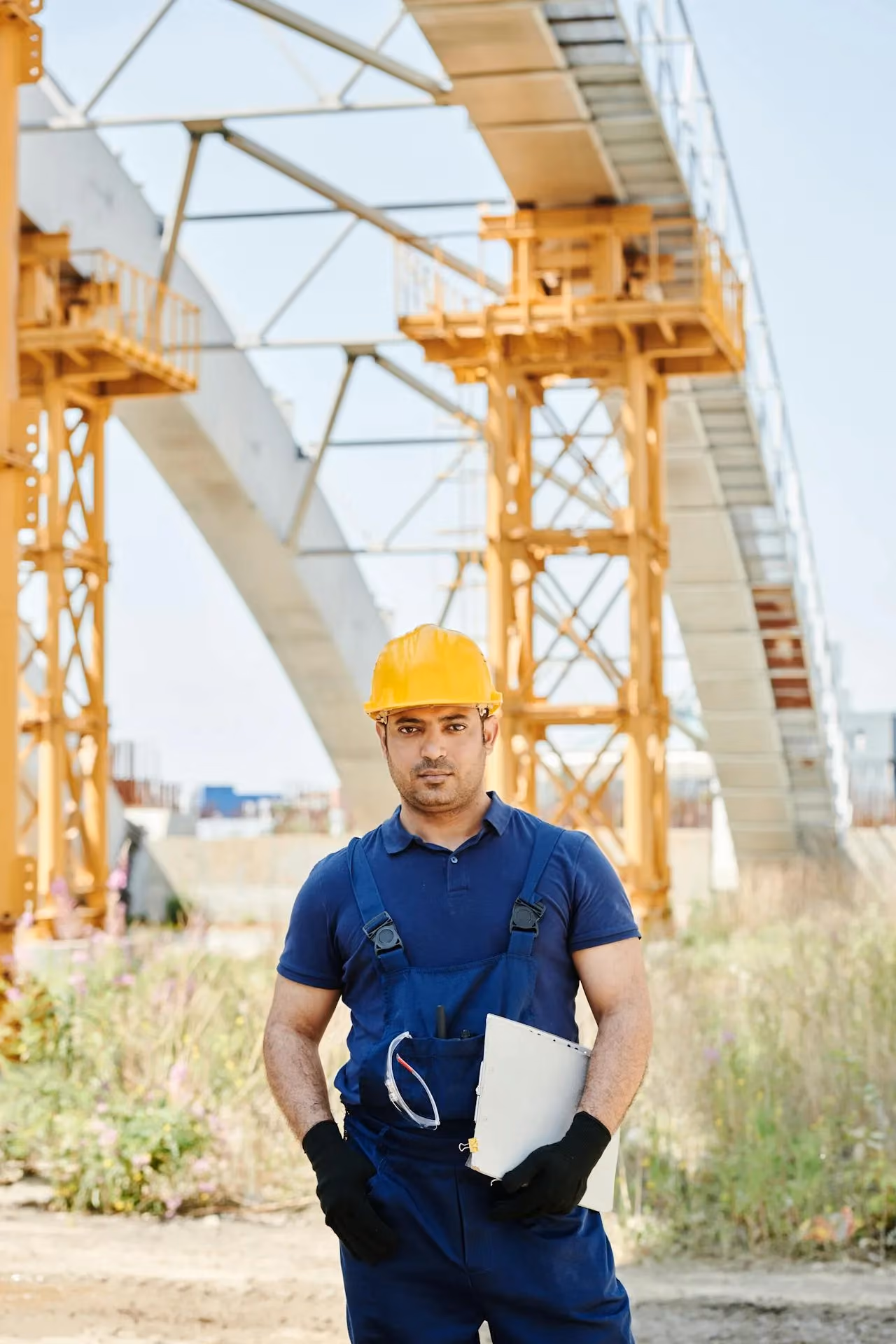 Engineer with hard hat and clipboard at a construction site